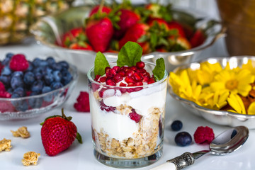Breakfast with muesli, yogurt, fruits and edible flowers