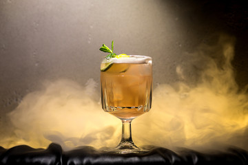 dark and stormy rum cocktail with Lime against background of smoke
