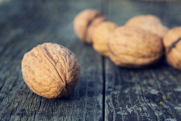 Vintage filtered close up of ripe walnuts on wooden table background copy space