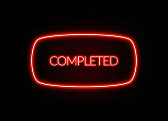 Completed neon sign on brick wall background.