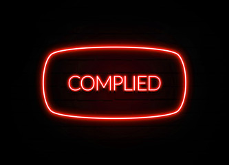 Complied neon sign on brick wall background.