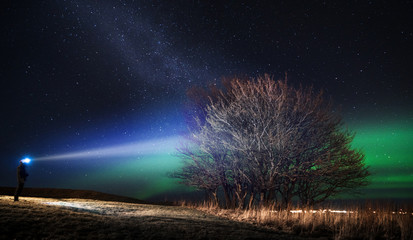Man standing with headlamp looking at nightsky. © Thomas