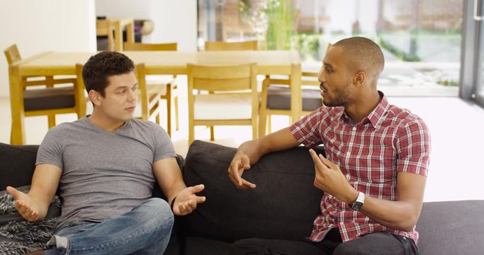 4K Young male friends relaxing at home & having serious conversation - man discussing relationship problems with his friend. Slow motion