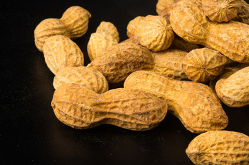 Peanuts in shell on dark background, close up
