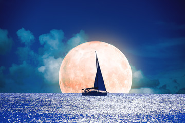 Fototapeta premium Sylwetka łodzi z pełni księżyca na oceanie.
