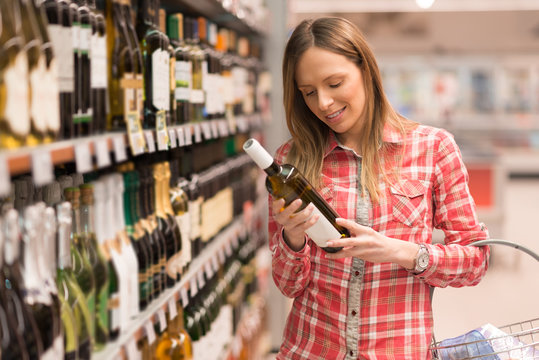 Young Woman Shopping For Wine In Grocery Store