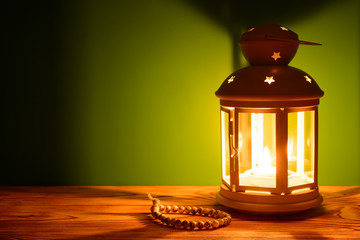 Holy month of Ramadan Karim background. Bright lantern and beads on the table with a copy space © Ramil Gibadullin