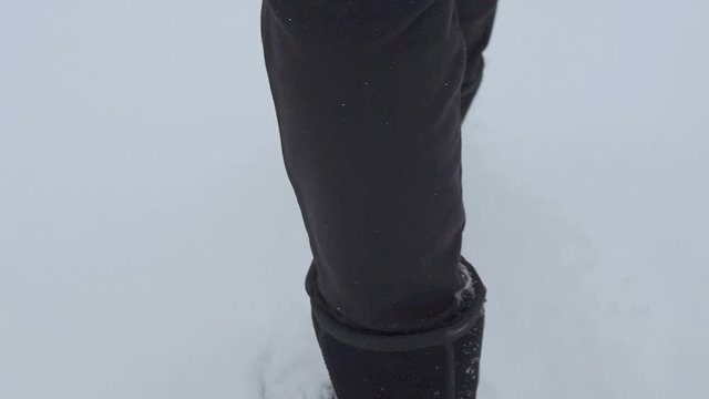 black boots go on white snow in winter