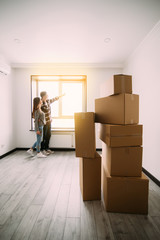 Fototapeta premium Young dreamy couple sitting on the floor after moving in new apartment