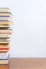 Stack of different books on a woogen table