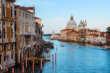 Beautiful panoramic view over the famous Grand canal in Venice, surrounded by old and romantic architecture illuminated by sun, in Italy. Natural colors