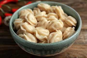 Bowl with tasty meat dumplings on table, closeup