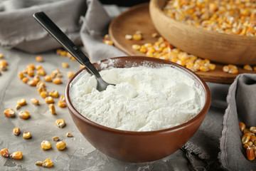 Bowl with corn starch and kernels on table