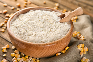Bowl with corn starch and kernels on table