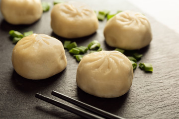 Slate plate with tasty baozi dumplings, closeup