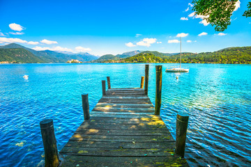 Orta Lake landscape. Wooden pier or jetty and Orta San Giulio village and island, Italy