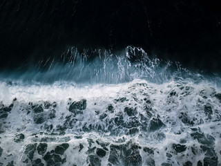 Abstract aerial of a cinematic crashing wave on a beach on Madeira, Portugal