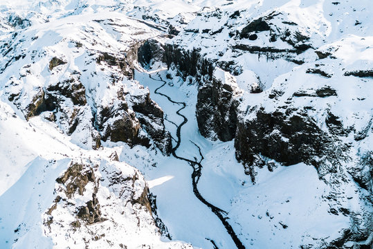 Aerial Snowed in Canyon with river in the Icelandic highlands during sunrise 