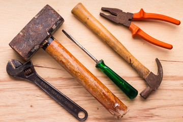 Screwdrivers, hammer, pliers and tools on a wooden table