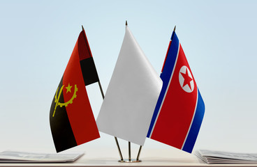 Flags of Angola and North Korea with a white flag in the middle