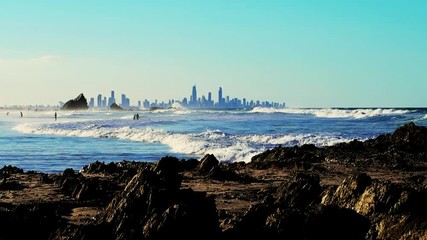 Eye Level Extreme Long Shot from a rocky shoreline looking over the ocean with the city of Surfers Paradise, Gold Coast, Australia in the distance.