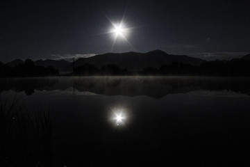 Full moon over the mountains at the lake in Colorado