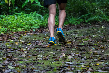 marathon runner running in rocks mountain. closeup of legs compression socks and shoes