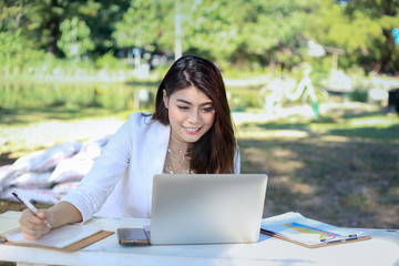 Young Asian woman enjoy her work in the park