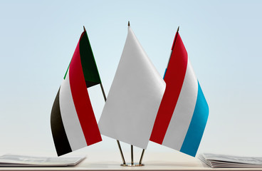 Flags of Sudan and Luxembourg with a white flag in the middle