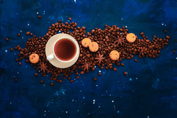 Frame with coffee cup, chocolate chip cookies and scattered coffee beans. Top view hot drink photography with copy space.