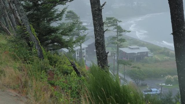 Pan Oregon coast homes and ocean during a rain storm.