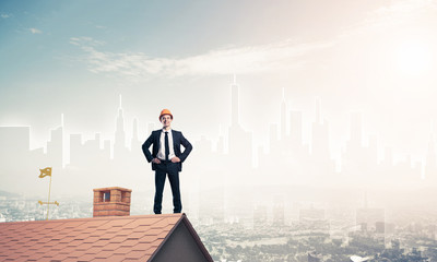 Engineer man standing on roof and looking away. Mixed media