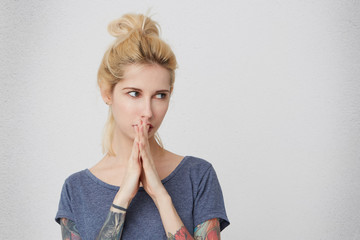What i've done? Portrait of astanished and sad young pretty blonde girl looking aside, prays and...
