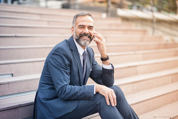 Senior businessman relaxing in an urban area, having a break from work