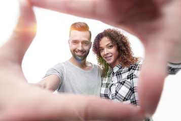 Fototapeta premium newlyweds look in the frame of the fingers.