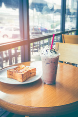 Garlic butter bread and ice chocolate with wipping cream at cafe.