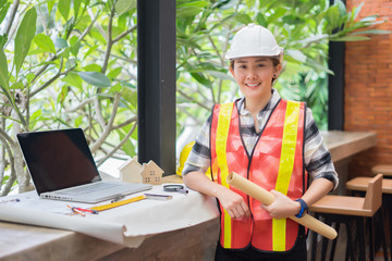 Fototapeta premium Architect women working on a blueprint. Architects workplace - architectural project, blueprints, ruler, calculator, laptop and divider compass. Construction concept. Engineering tools,selective focus
