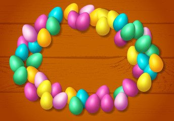 Easter frame with shiny colorful happy eggs spread over wooden background