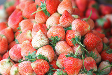 Fresh red strawberry pile on background for sale at market