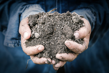 soil in farmer hands macro image with selective focus