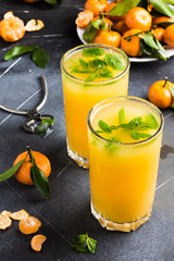 Tangerine juice in glasses on light background
