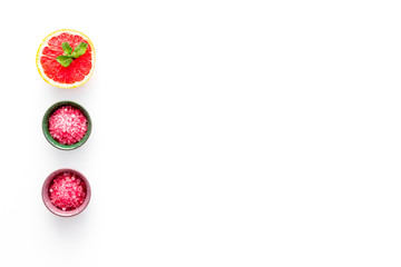 Natural citrus cosmetics. Spa salt near grapefruit on white background top view copy space
