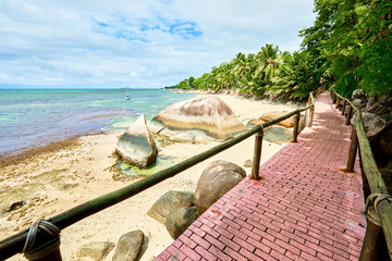 walkway on coastline of anse cimitiere, tropical beach, Praslin, Seychelles