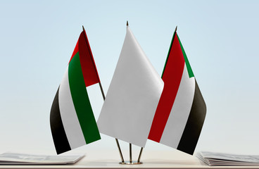 Flags of UAE and Sudan with a white flag in the middle