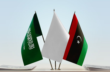 Flags of Saudi Arabia and Libya with a white flag in the middle