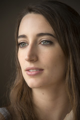 Head and shoulders portrait of young woman in windor light.