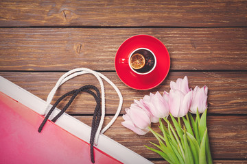 Cup of english tea with spring tulips and shopping bags