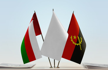 Flags of Oman and Angola with a white flag in the middle