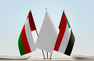 Flags of Oman and Sudan with a white flag in the middle
