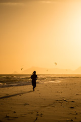 Fototapeta na wymiar Silhouette of man running on the beach during sunset